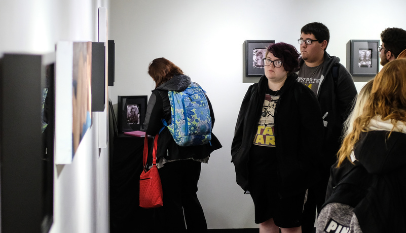 People looking at art on the wall