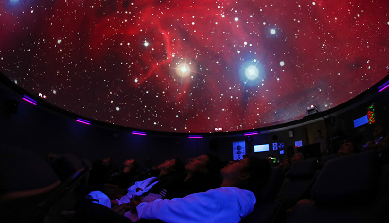 visitors to the planetarium enjoy a show