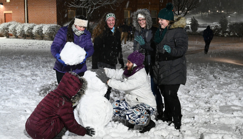 Students building a snowman