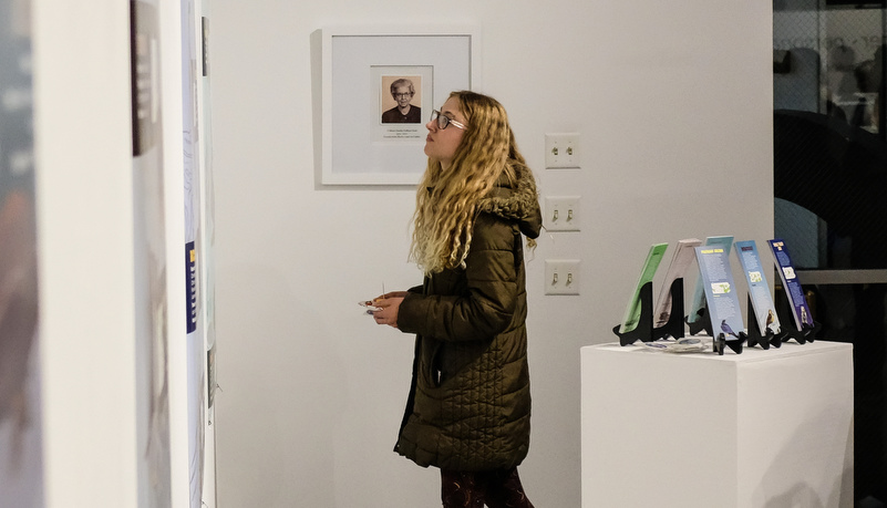 A woman looking at art hanging on the wall