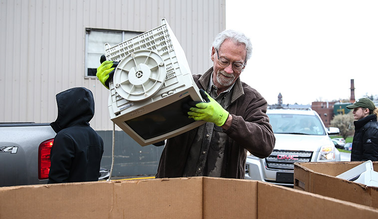 Man recycling an old computer monitor