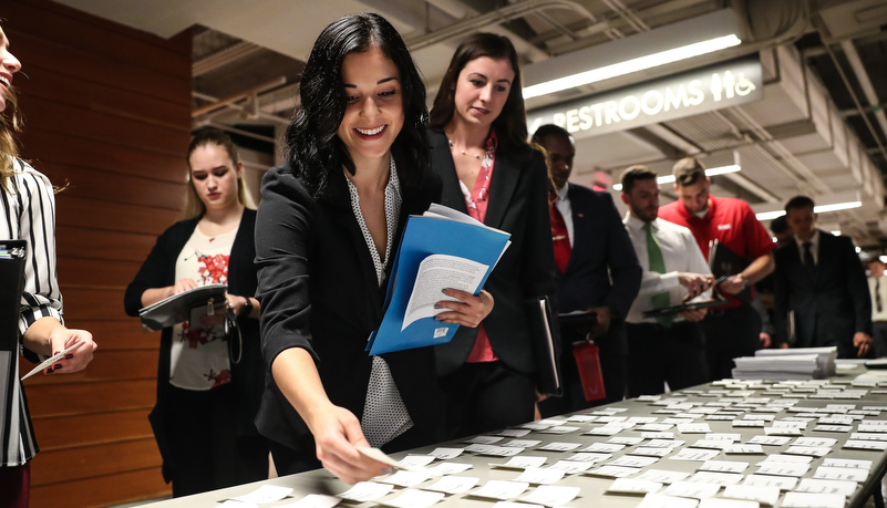 woman picking up her name tag