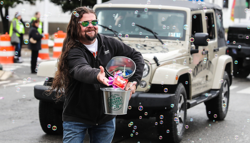 man in parade throwing candy