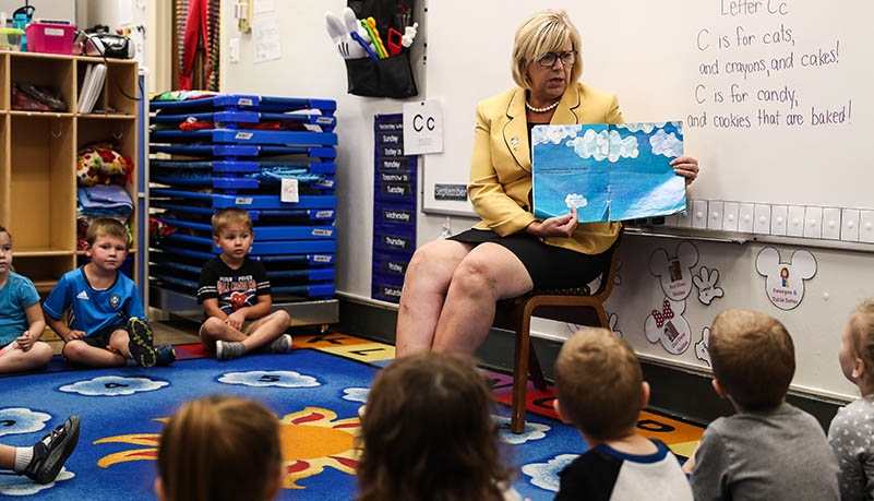 Woman reading to pre school students