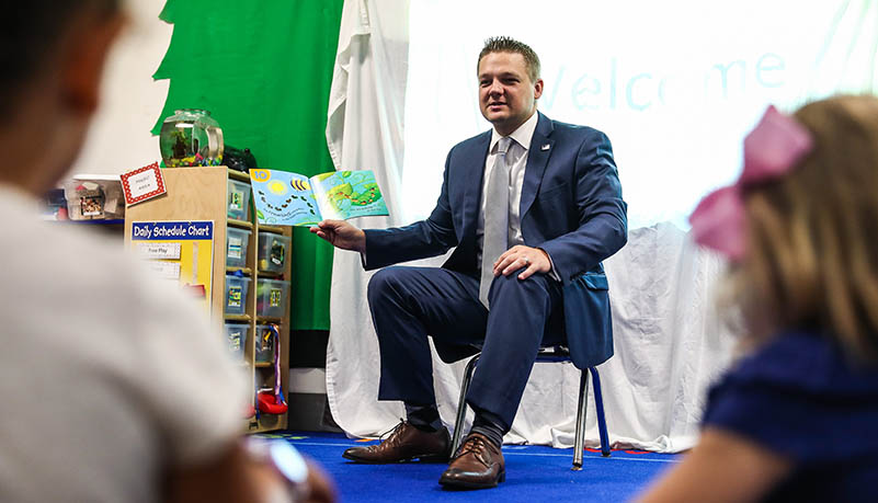 Man reading to pre school students