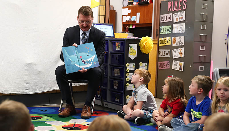 Man reading to pre school students
