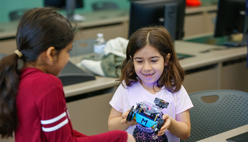 Two children holding robot