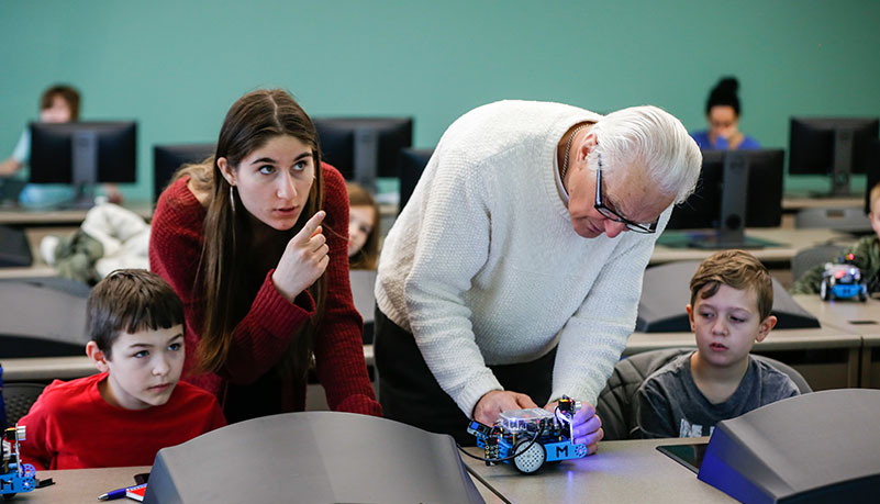 two instructors helping children learn