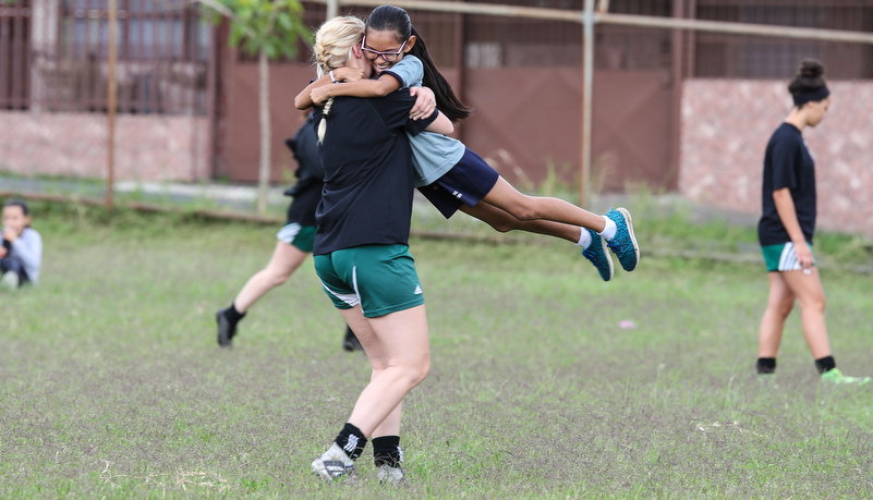 soccer player plaing the game with a school boy