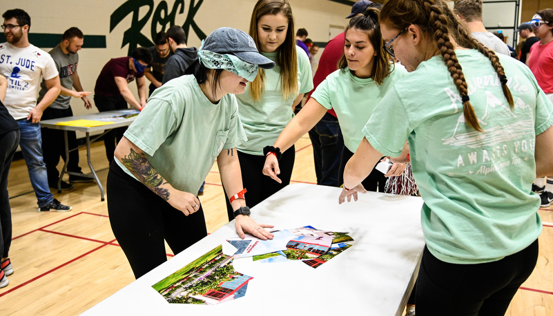 Students play a game trying to put a photo together while blindfolded