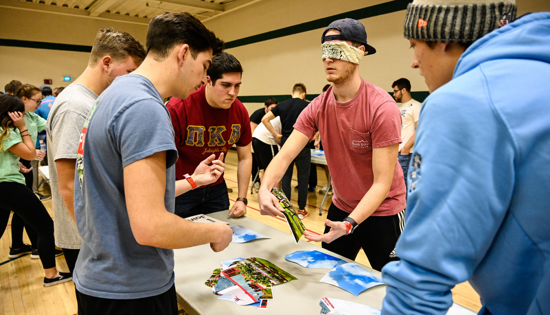 Students play a game trying to put a photo together while blindfolded