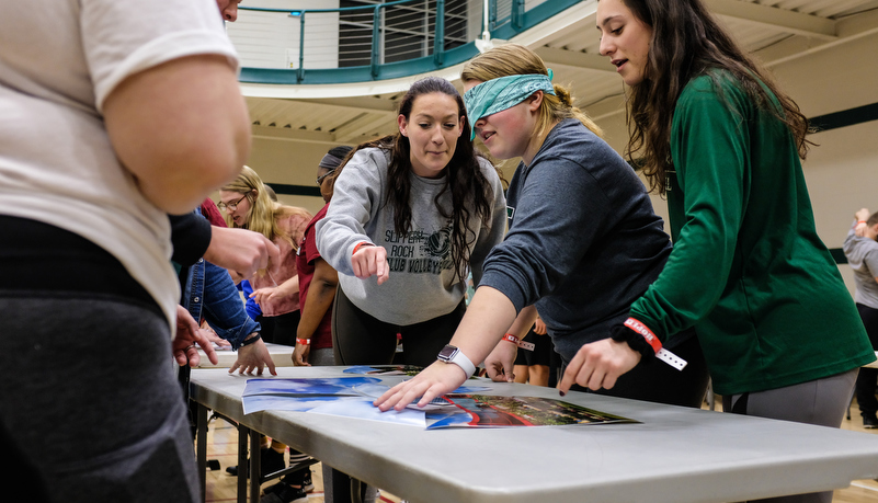 Students play a game trying to put a photo together while blindfolded