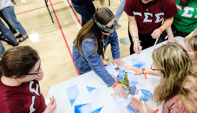 Students play a game trying to put a photo together while blindfolded