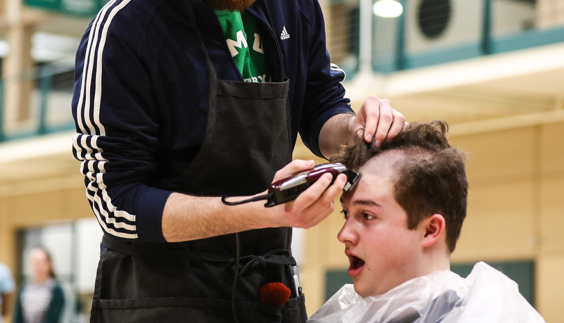 Student getting his head shaved after raising money to do so