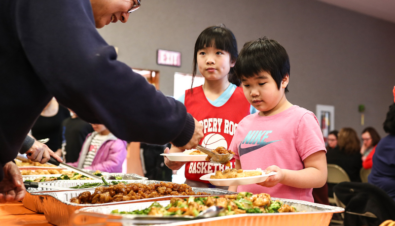 Girl selecting CHinese food to eat