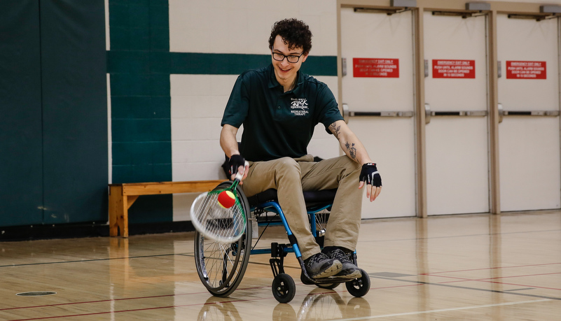 Man pplaying tennis in a wheel chair