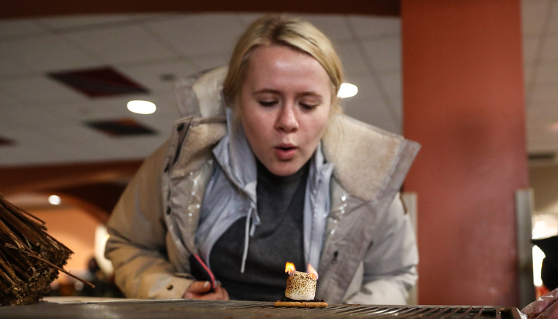 Woman extinguishing a flmae on a marshmallow