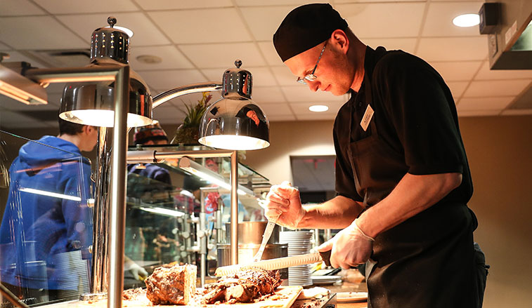 AVi chef cutting meat