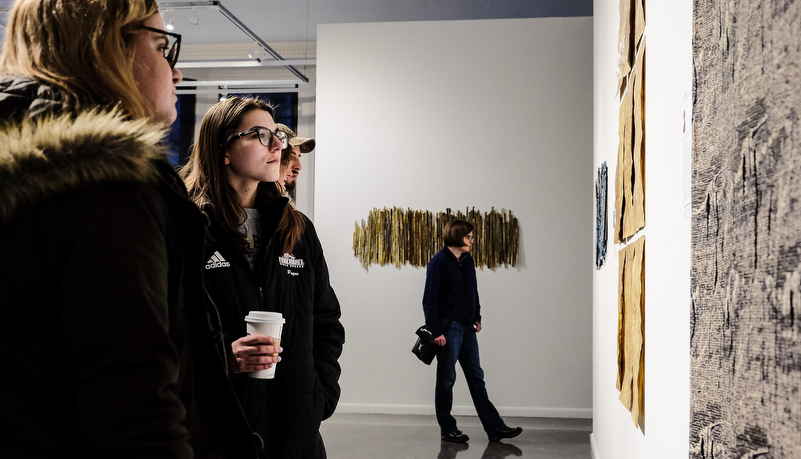 a woman looking at art on display