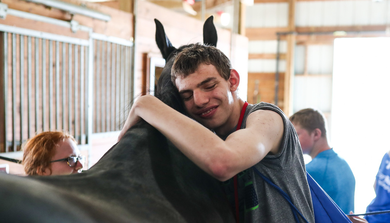 camper hugging his favorite horse