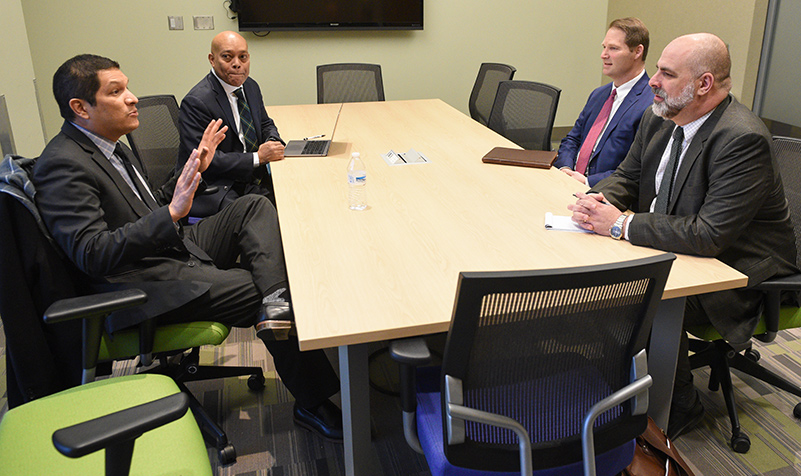 Four people talking at business table