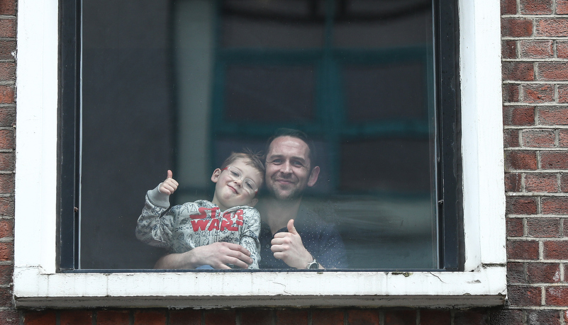 Father and son looks down from their apartment