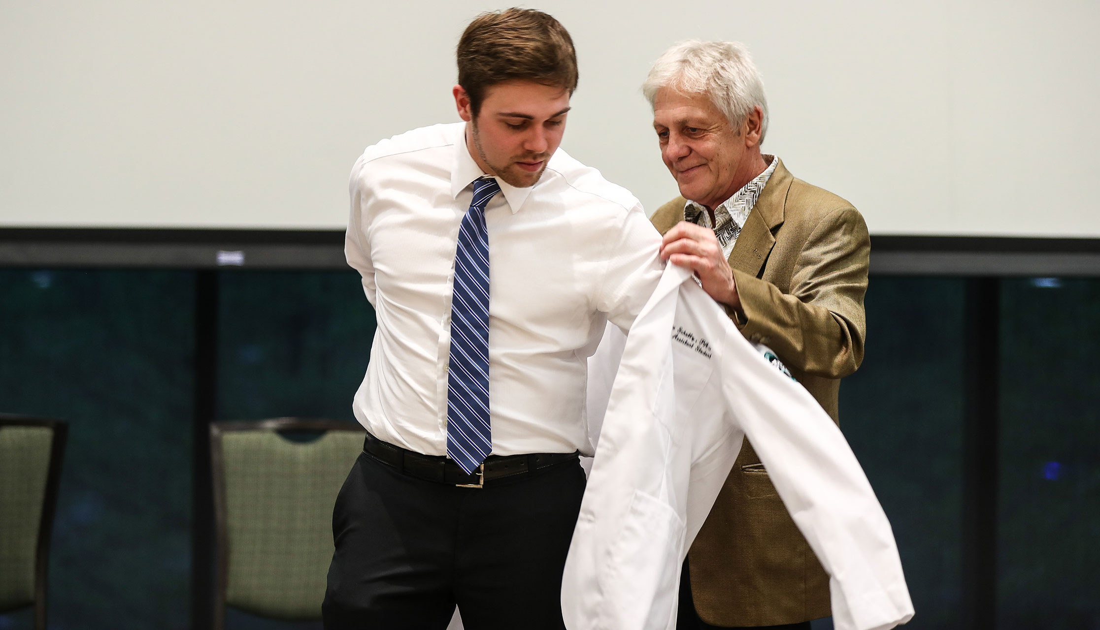 man receivers her white coat