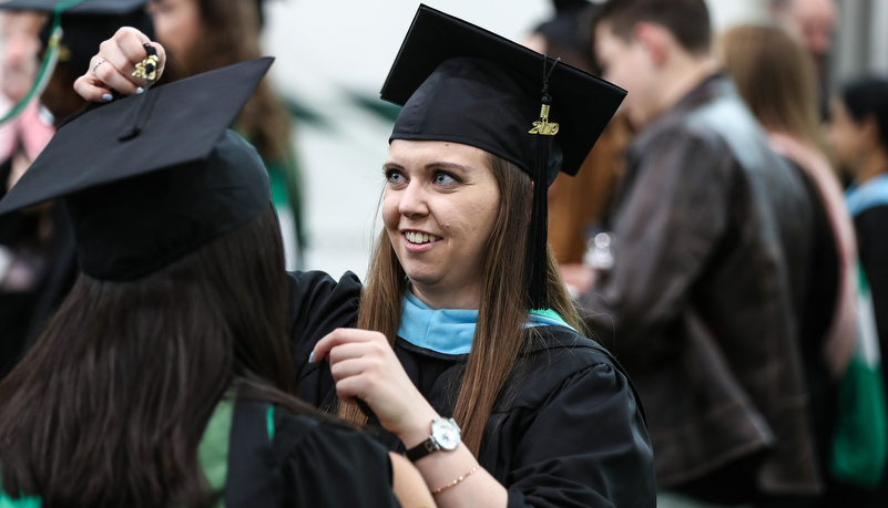Woman helping with a graduates cap