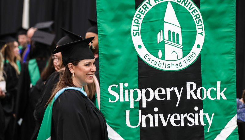 Graduate with the university banner