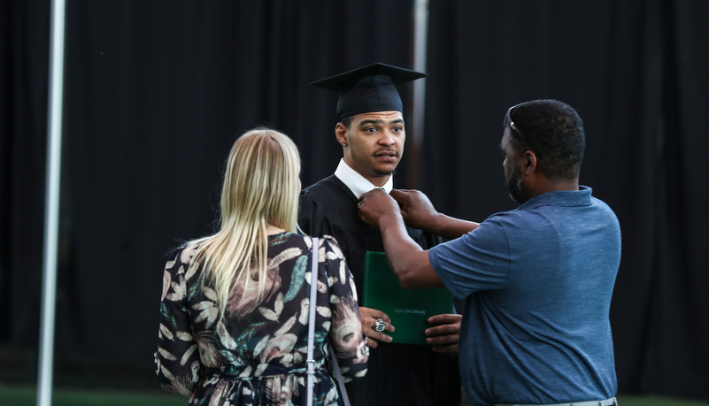 student poses for a photo with family