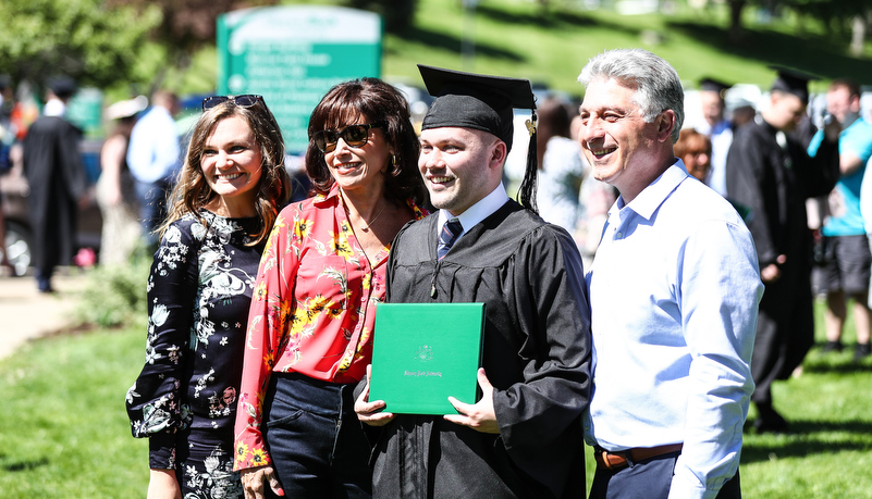 student poses for a photo with family