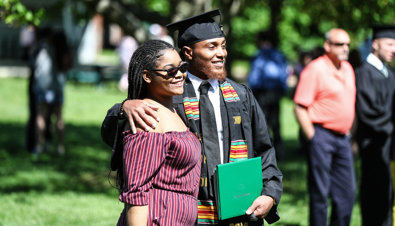 student poses for a photo with family