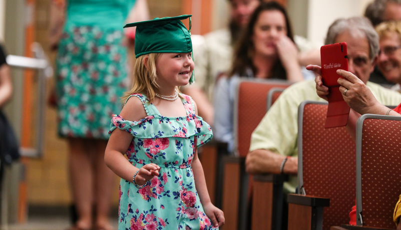 Girl enters wearing a graduation cap 