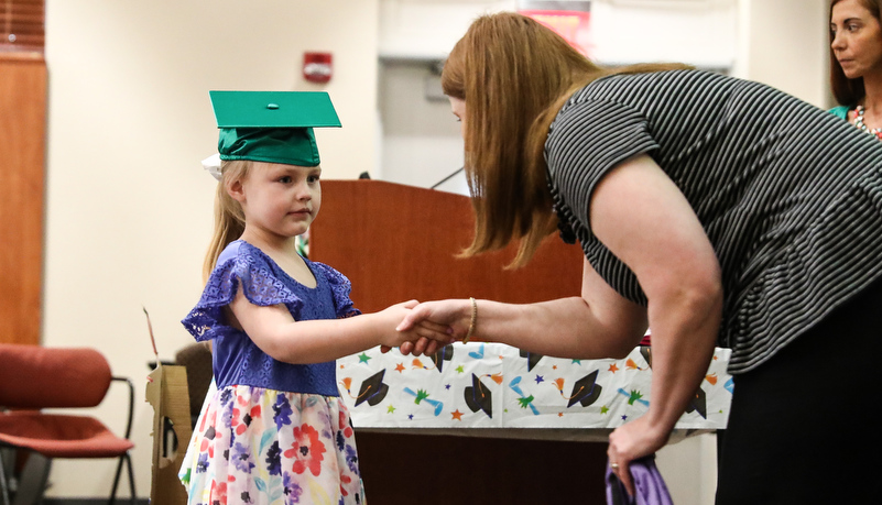 girl receives her pre-school diploma
