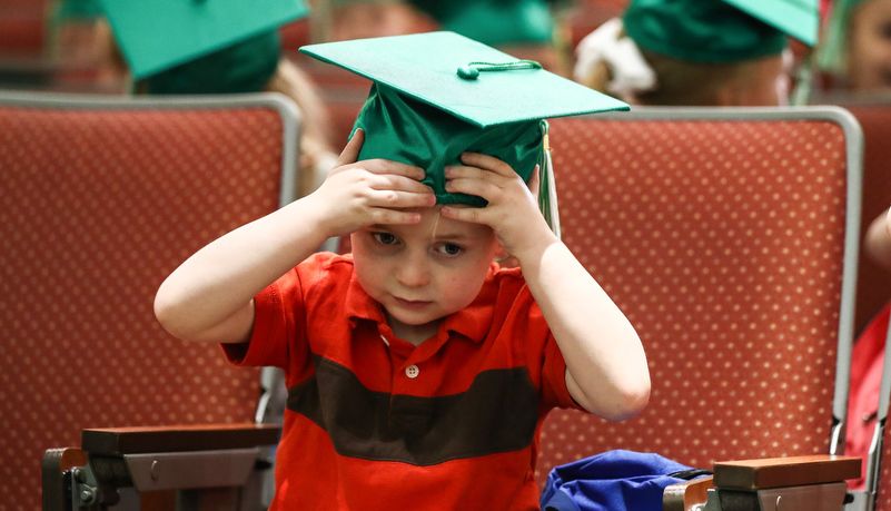 Boy adjusts his cap