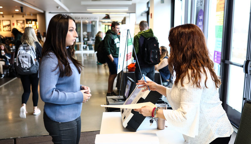 Student usiing the new voting machines