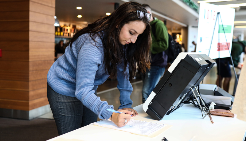 Student usiing the new voting machines