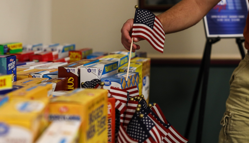 faculty member placing an American flag in a vase