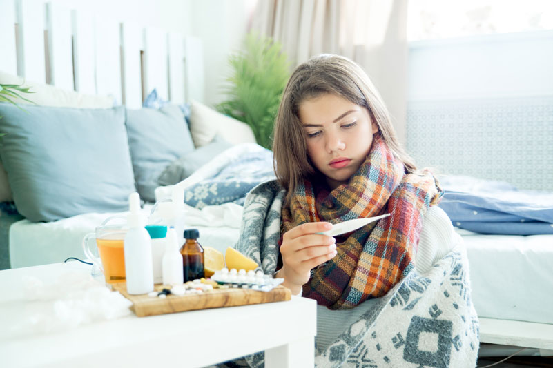 Sick looking female testing temperature