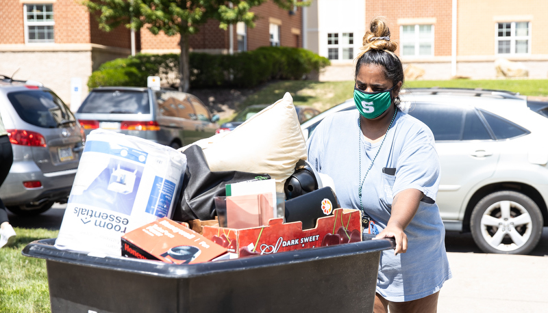 Woman moving her belongings in a cart