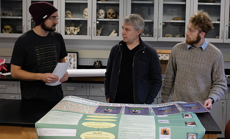 Students and their professor reviewing the game.