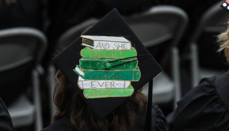 Cap decorated with a painting of a stack of books