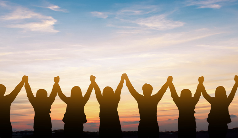 people holding hands at sunset