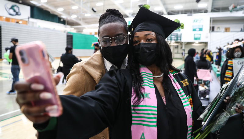 Graduate stops for a photo with a friend