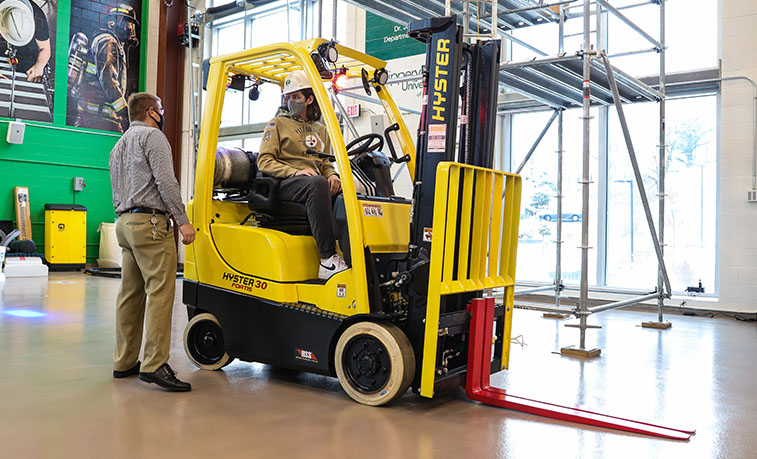 Student with professor learning about the new forklift