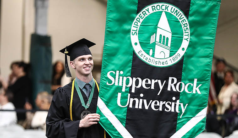 graduate carrying the university flag