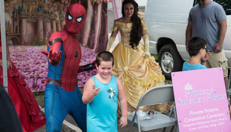 Spiderman poses with a kid for a photo