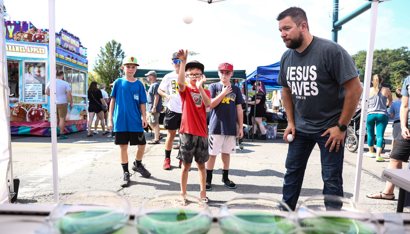 Kid tossing balls into glasses