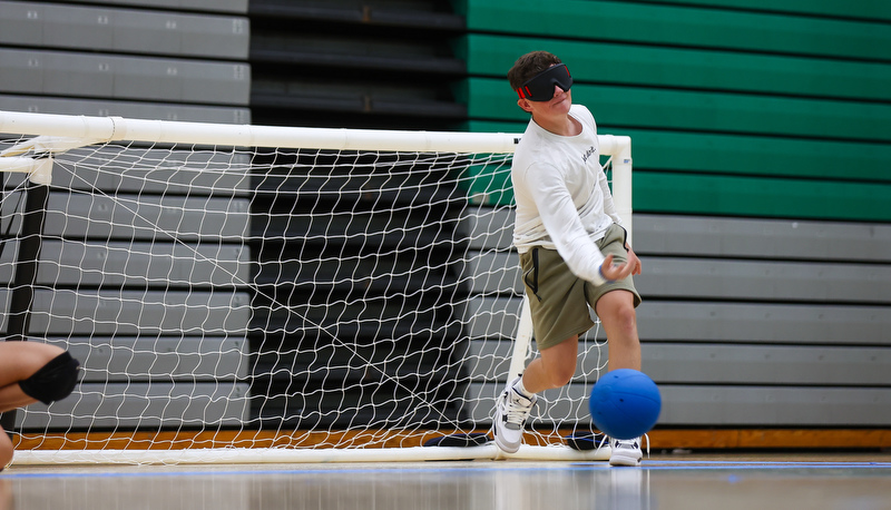 Another student blindly rolling a ball to the goal