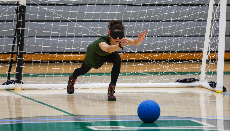 Student blindly rolls ball down the court